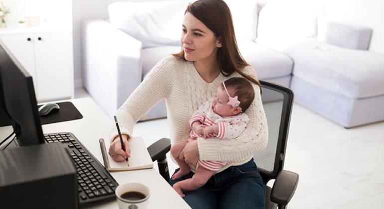 Mãe trabalhando com filha no colo